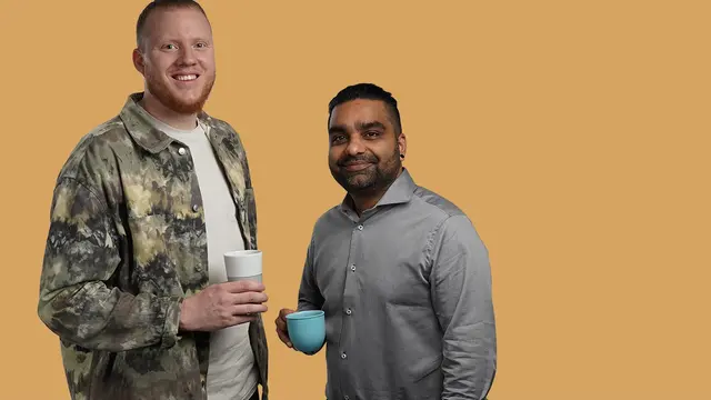 Medarbetare på Euro Accident står med kaffekopp och ler