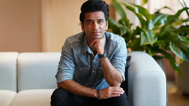 Mudasir Khan, an employee in IT, is sitting in a sofa and resting his chin on his hand