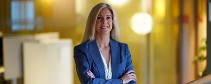 Trött man vid skrivbord lutar pannan i handen